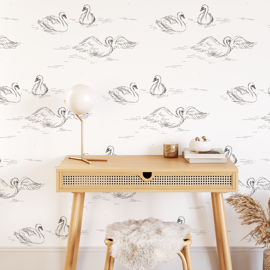 This picture shows our peel and stick, removable Swans wallpaper in cream by artist Rose Lindo and is displayed on an office wall.