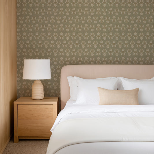 Neatly made bed with white bedding and beige pillows in a bedroom setting. Wallpaper is Large Antique Floral Rows in sage green colors.
