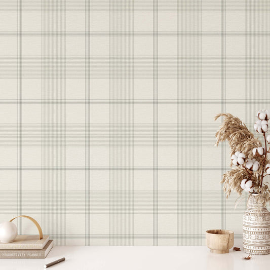 Plaid patterned wallpaper with a vase of cotton and decorative items on a white surface.