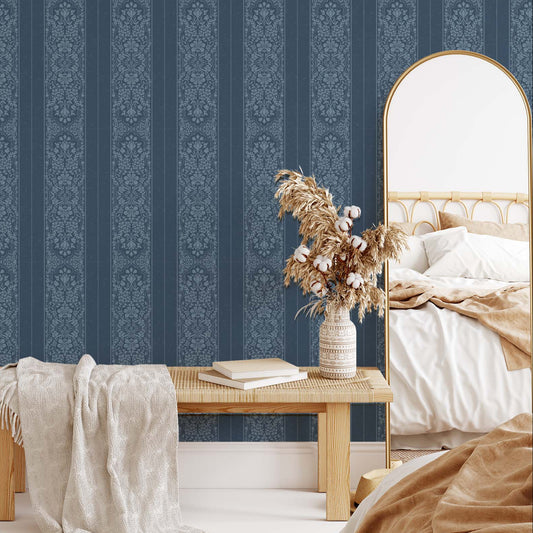 Bedroom with blue striped wallpaper, wooden bench, and decorative mirror.