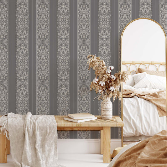 Bedroom with striped wallpaper, wooden bench, and decorative mirror.