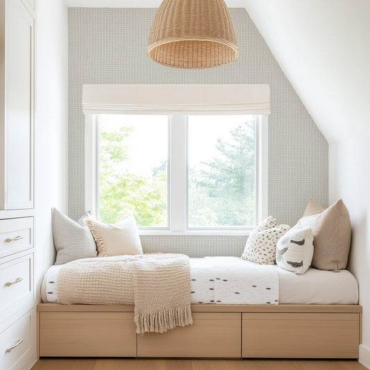 Nestled corner of a bedroom with a bed, pillows, and a large window featuring our Large Geometric Dots Wallpaper in Gray Blue.