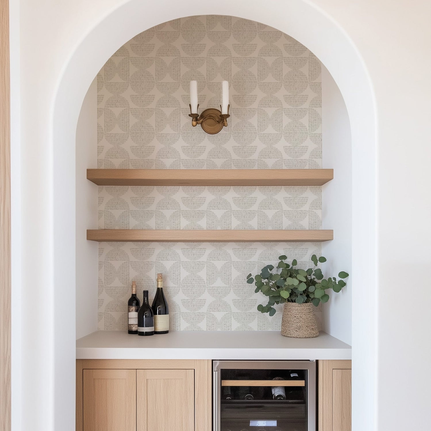 Modern kitchen with wooden shelves, wine bottles, and a plant. Featured wallpaper is Half Circle Blocks, a geometric wallpaper by Ayara.
