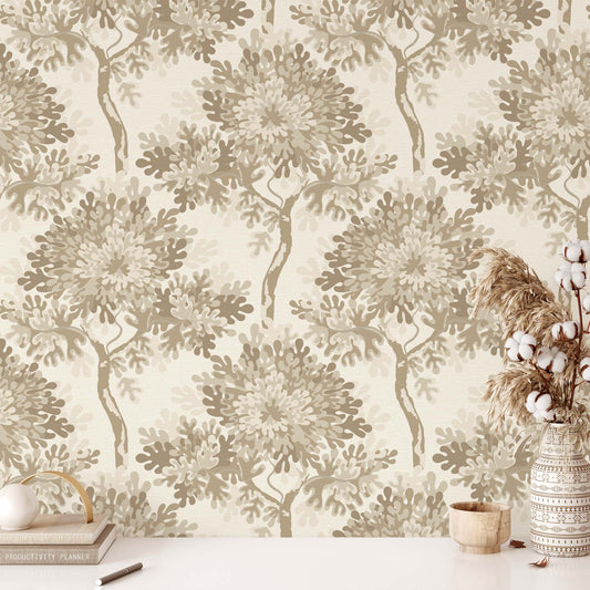 Wallpaper with tree and leaf pattern in neutral tones, with a vase and decor items on a table.