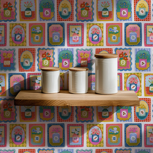 Three ceramic jars with wooden lids on a wooden shelf against a colorful patterned wall.