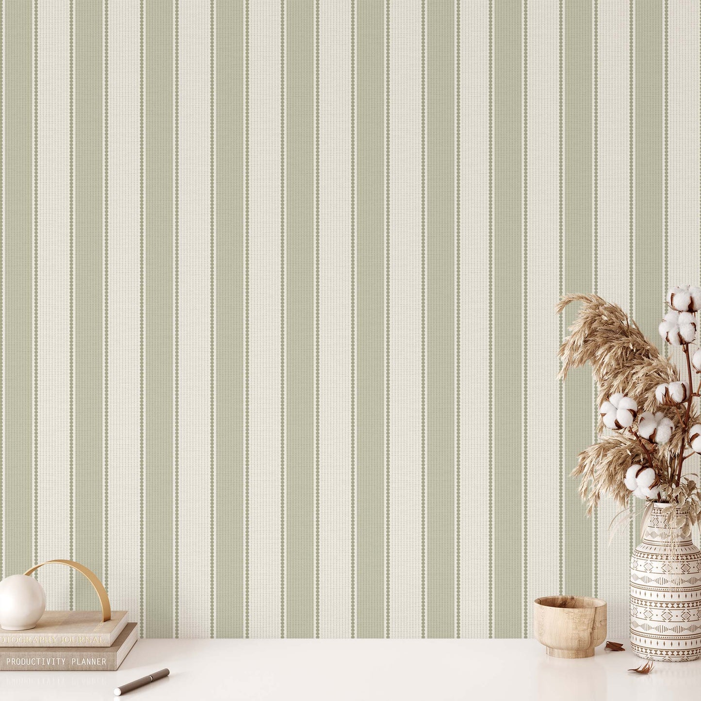 Striped wallpaper with a vase of cotton and decorative items on a table