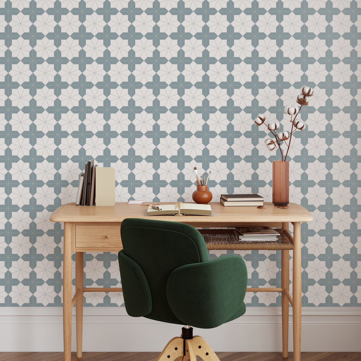 Wooden desk with green chair against a patterned wallpapered wall.