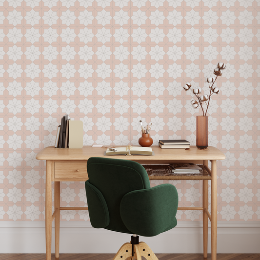 Wooden desk with a green chair against a peach wallpapered wall.