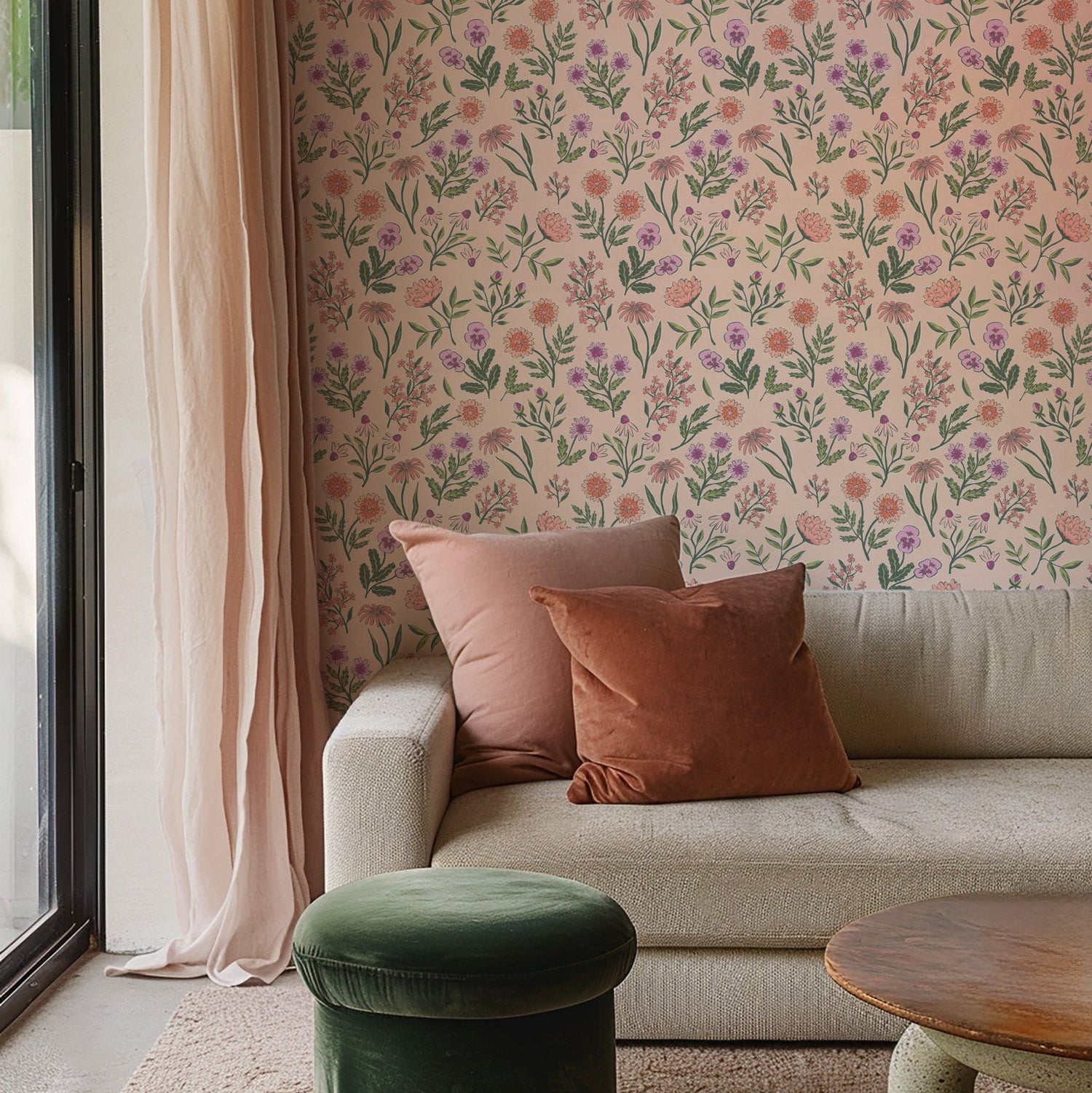 Living room with floral wallpaper on a peach background with a beige sofa and green ottoman.