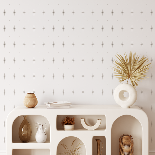 Decorative shelf with various items against a wallpapered wall.