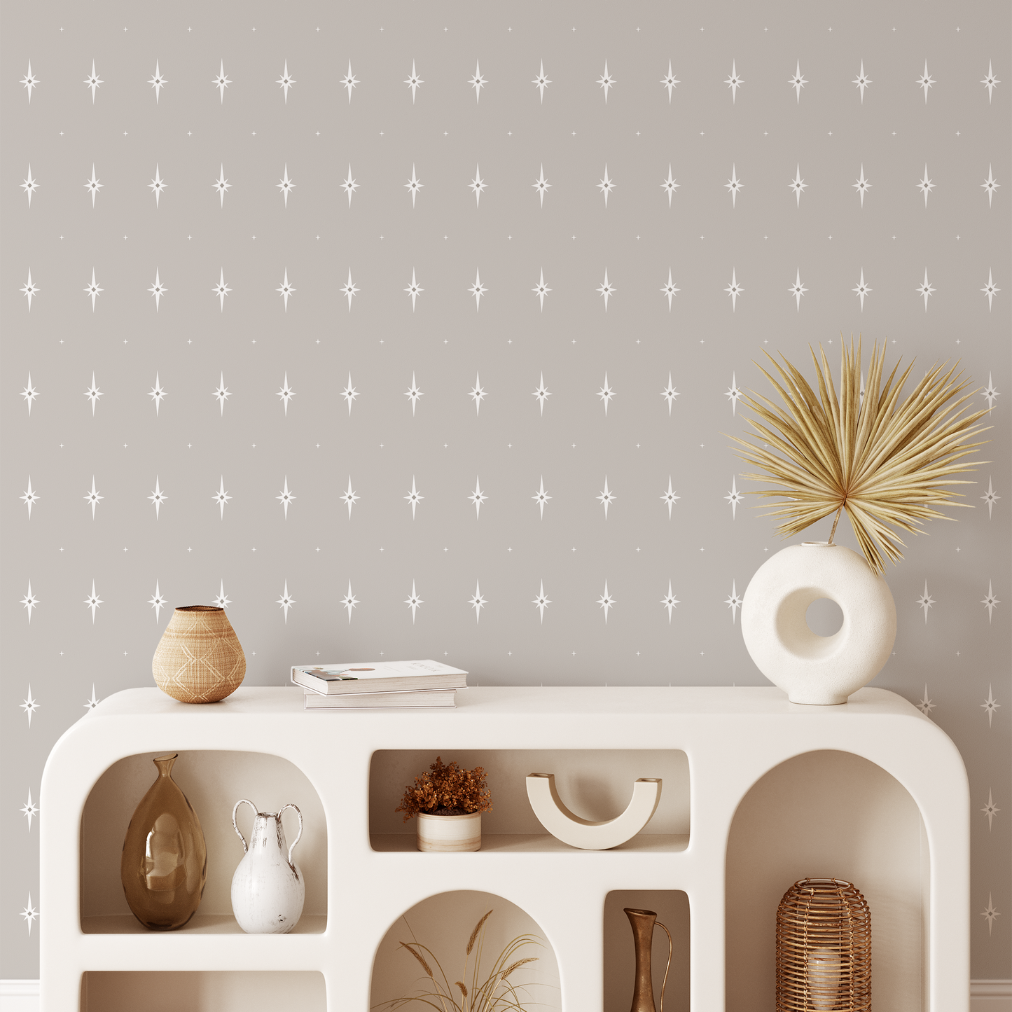 White shelving unit with decorative items against a taupe wall with a star pattern
