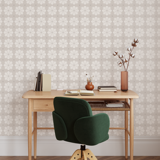 Wooden desk with a green chair against a patterned wallpaper wall.