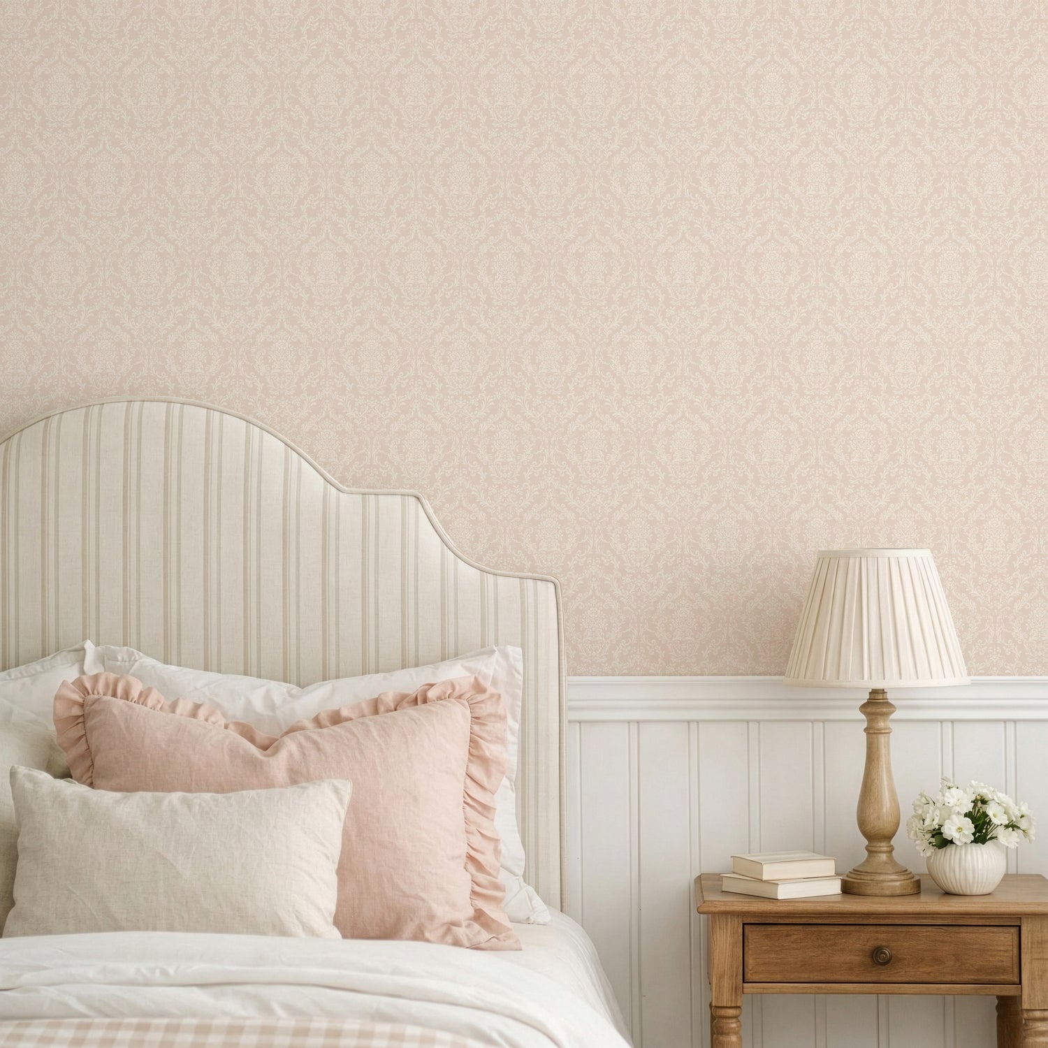 Mira Damask Wallpaper in Blush shown in a bedroom.