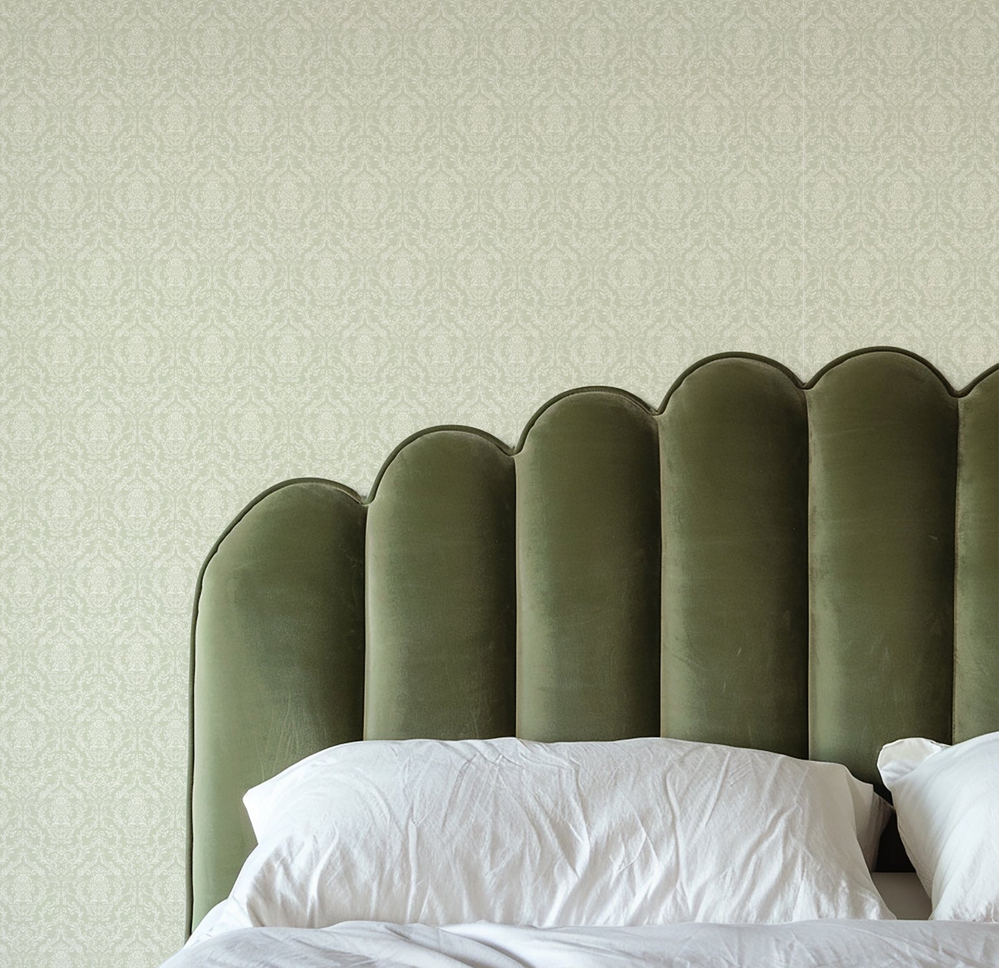 Mira Damask Wallpaper in Sage shown in a bedroom,