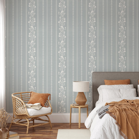 Sweet Floral Stripe Wallpaper in Cloudy Blue shown in a bedroom