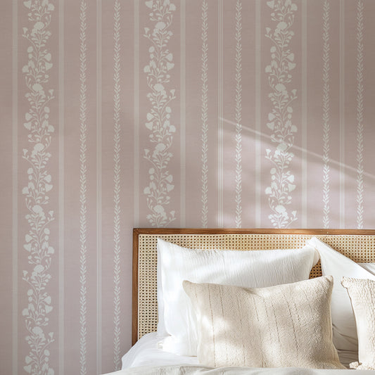 Sweet Floral Stripe Wallpaper in Rose shown in a bedroom