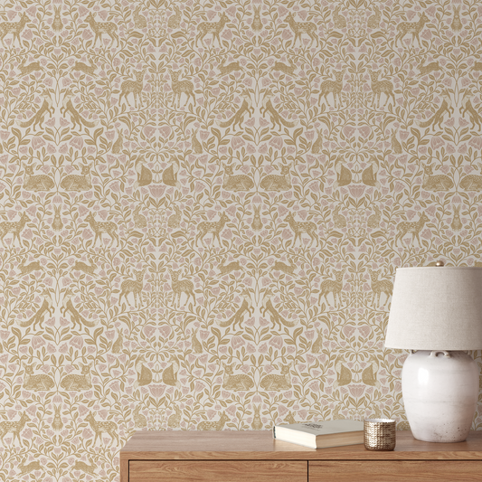 Woodland wallpaper in gold on a wall with a table and lamp