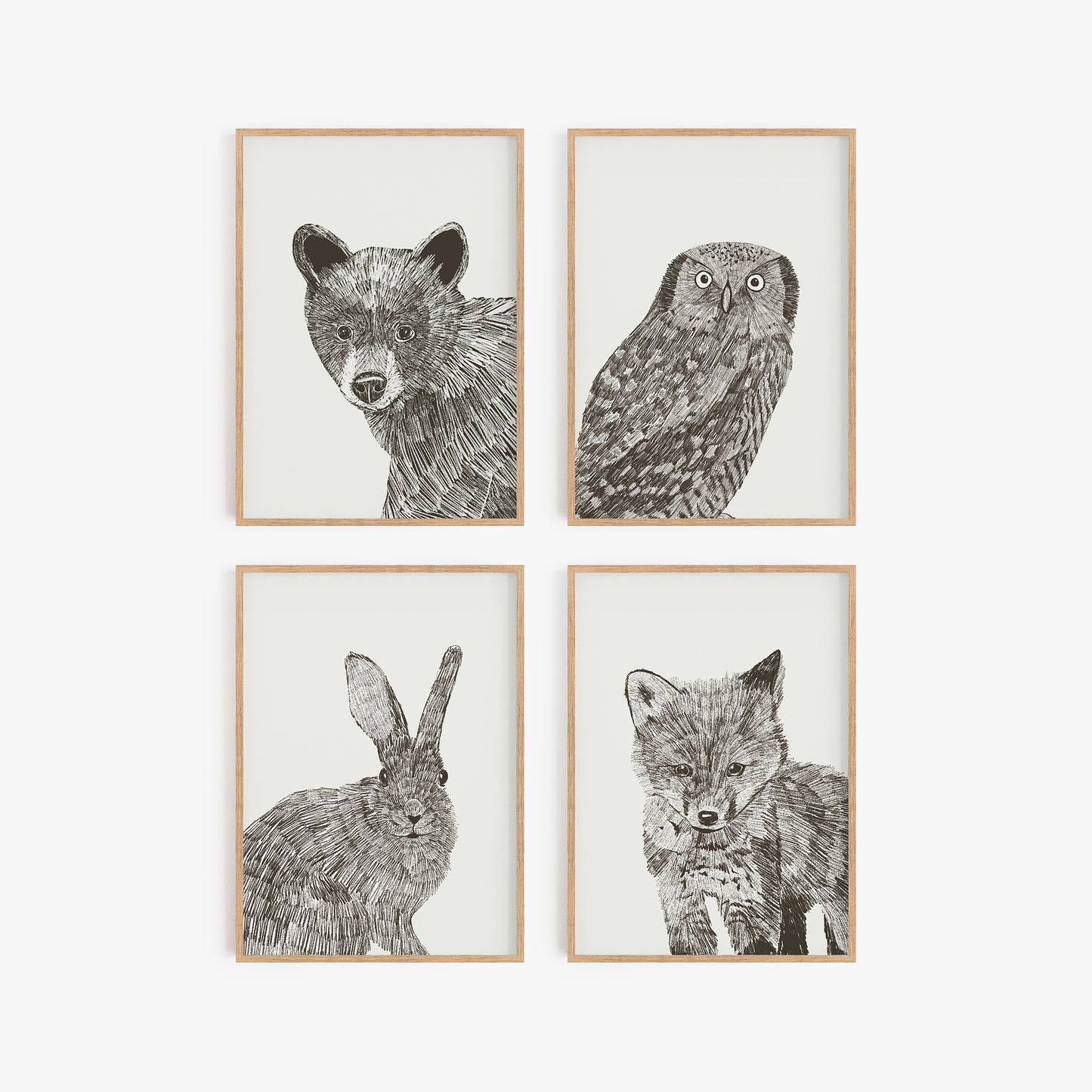 Set of four art prints with woodland creatures: owl, bear, bunny, and fox. Sketched in black and white. Comes in a set of four unframed art prints.