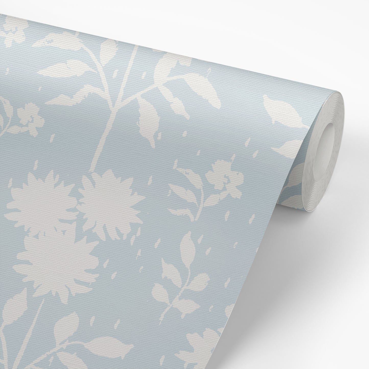 View of roll of peel-and-stick wallpaper with a design of white florals with a light blue background