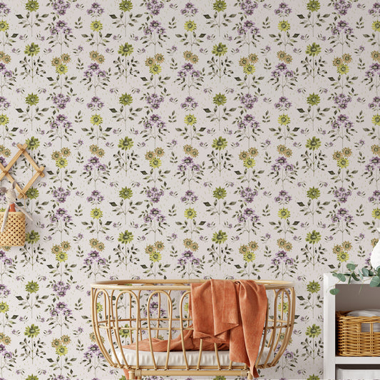 View of peel-and-stick green and lavender wallpaper on a wall of a baby nursery with a baby crib and blanket.