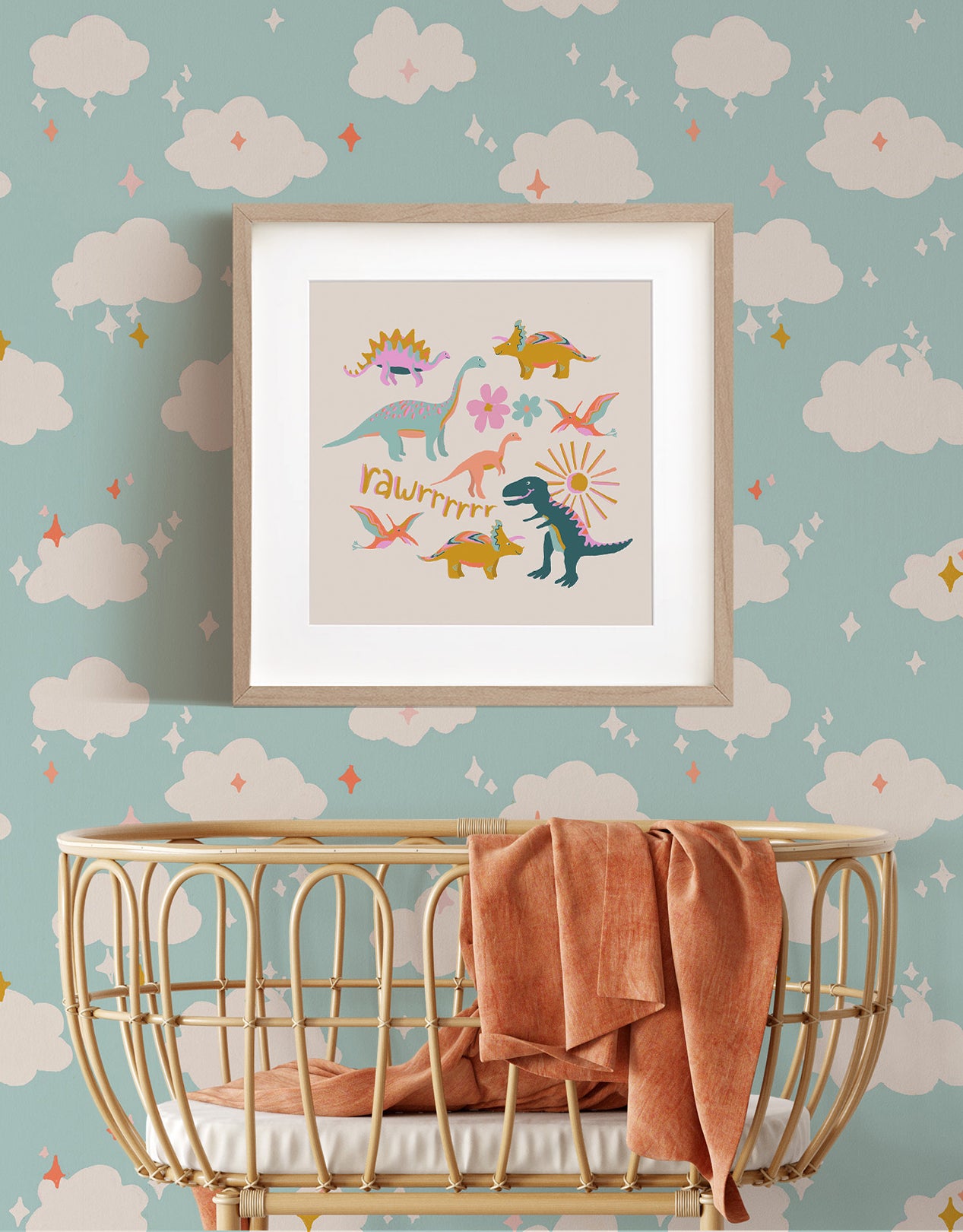 Nursery wall featuring a clouds wallpaper. Fun, colorful dinosaurs come to life in this Dinos art print designed by Iris + Sea for Ayara.