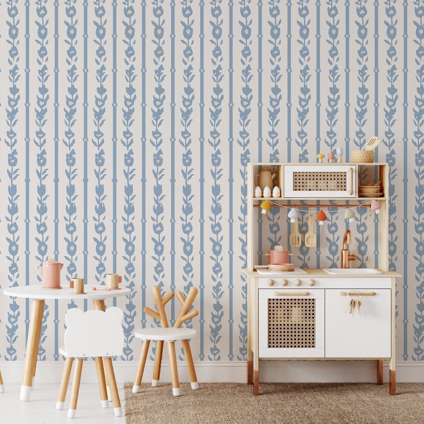 Playroom wall featuring our oversized floral and stripe Esme peel and stick wallpaper in light blue, grey, and off white by Jackie O'Bosky.